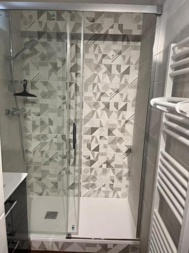 une douche avec une porte vitrée dans une salle de bain dans l'établissement Appartement Saint Lary Soulan, à Saint-Lary-Soulan