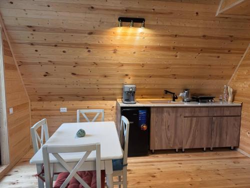 a kitchen with wooden walls and a table and a stove at Mtiskari cottage in Utsera in Utsera