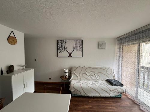 ein Wohnzimmer mit einer weißen Couch und einem Fenster in der Unterkunft Appartement Saint Lary Soulan in Saint-Lary-Soulan