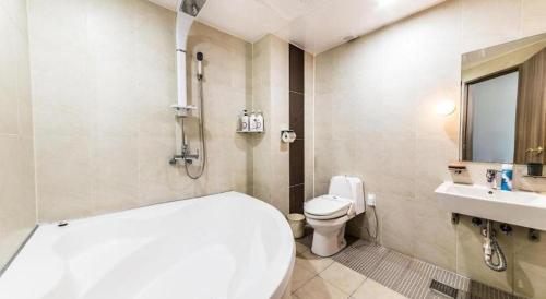 a bathroom with a white toilet and a sink at Nostalgia Hotel in Paju
