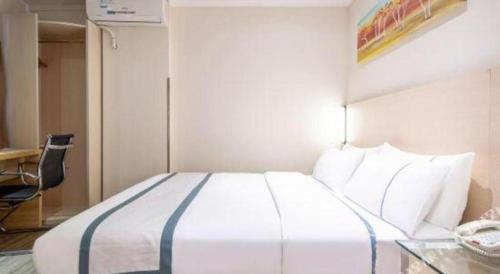 a bedroom with a bed with a desk and a phone at City Comfort Inn Beihai RT-Mart High Speed Railway Station in Beihai