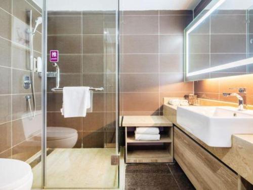 a bathroom with a sink and a toilet and a shower at Yitel Collection Lianyungang High-speed Railway Station Suning Plaza in Lianyungang