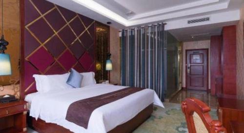 a bedroom with a large bed and a purple wall at Shenzhen Kai Long International Hotel in Shenzhen