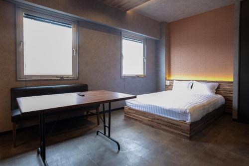 a bedroom with a bed and a desk and window at Pin pon hotel & cabin Tokuyama Ekimae - Vacation STAY 86387v in Shunan