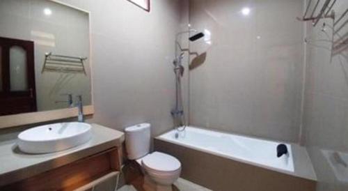 a bathroom with a toilet and a tub and a sink at Samosir Cottages Resort in Tuk Tuk
