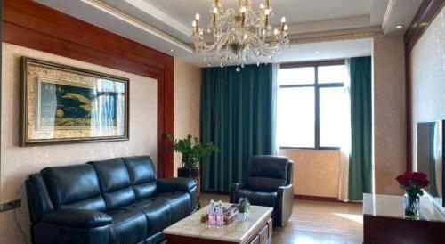 a living room with a leather couch and a chair at Shenzhen Kai Long International Hotel in Shenzhen