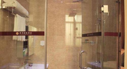 a shower with a glass door in a bathroom at Shenzhen Kai Long International Hotel in Shenzhen