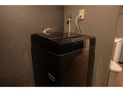 a bathroom with a black dresser with a telephone on it at Pin pon hotel & cabin Tokuyama Ekimae - Vacation STAY 86396v in Shunan