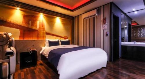 a bedroom with a bed and a sink and a tub at SKY Hotel in Changwon