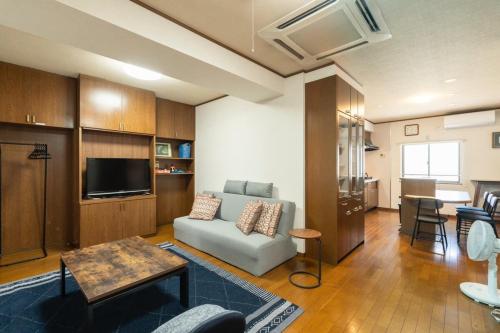 a living room with a couch and a tv at Guest House-空- in Takamatsu