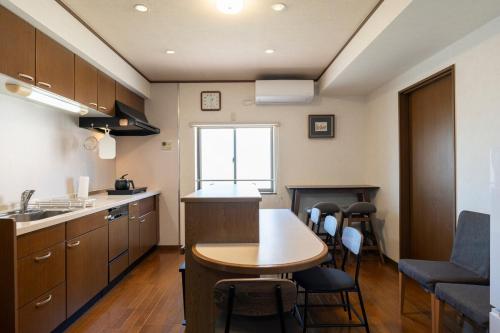 a kitchen with a table and chairs in a room at Guest House-空- in Takamatsu