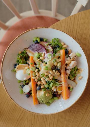 a bowl of vegetables with beans and carrots on a table at Aparthotel Treudelberg Hamburg in Hamburg