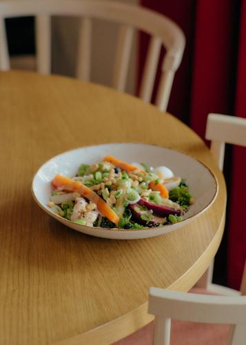 a bowl of vegetables sitting on a wooden table at Aparthotel Treudelberg Hamburg in Hamburg