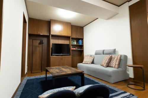 a living room with a couch and a tv at Guest House-空- in Takamatsu
