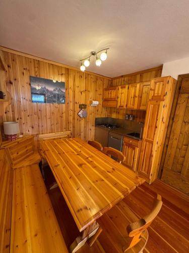 a large wooden table in a kitchen with wooden cabinets at Casa Gatto in Auronzo di Cadore