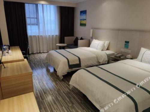 a hotel room with two beds and a couch at City Comfort Inn Nanning Zoo Keyuan Avenue in Nanning