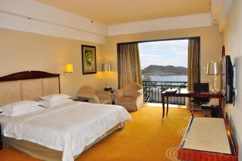 a hotel room with a bed and a balcony at Country Garden Phoenix Hotel Anqing in Renyuexing