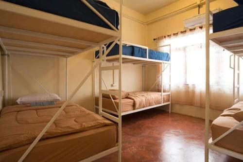 a room with two bunk beds and a window at Oldie and Sleepy Hostel in Udon Thani
