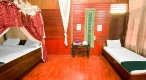 a small room with two beds and a table at Bunda House Syariah in Padang