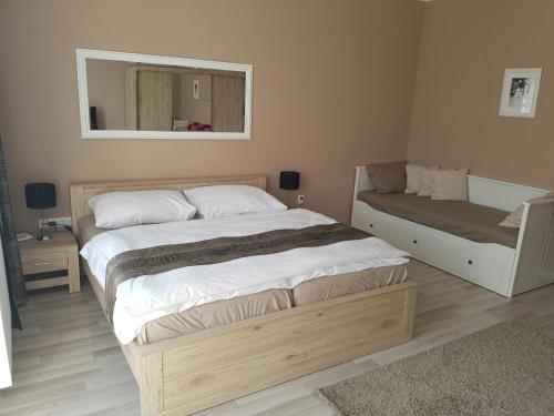 a bedroom with a large bed and a mirror at Ubytování Cukrovar in Lovosice