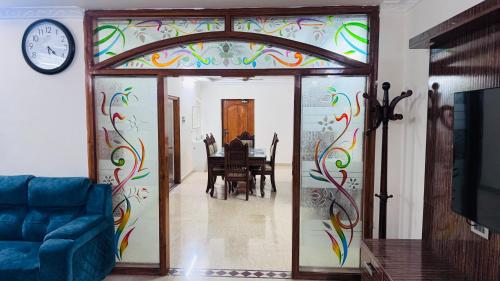 a living room with a wall with a colorful painting at Fortune Homestay Tirupati in Tirupati
