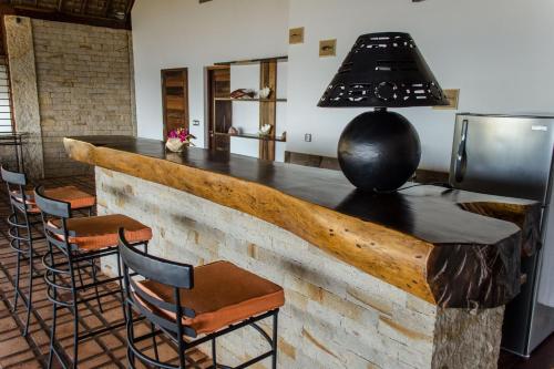 a kitchen with a bar with stools and a stove at Home The Residence in Befotaka Bay
