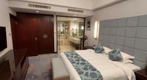 a bedroom with a large bed and a bathroom at Putian Haiyuan International Hotel in Putian