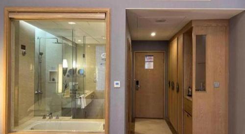 a bathroom with a tub and a shower and a mirror at Putian Haiyuan International Hotel in Putian