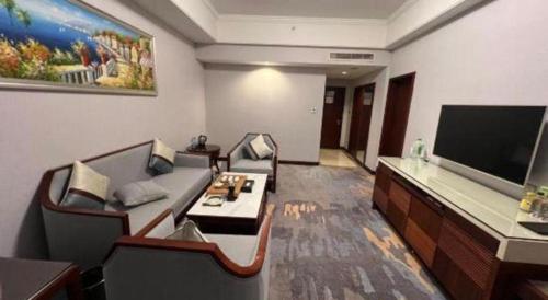 a living room with couches and a flat screen tv at Putian Haiyuan International Hotel in Putian