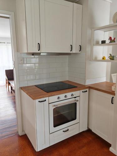 a kitchen with white cabinets and a stove at Three-bedroom house with pool & yard in Rochedale South