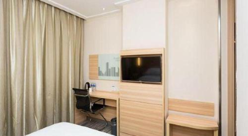 a hotel room with a bed and a desk and a tv at City Comfort Inn Xiangyang Railway Station in Xiangyang