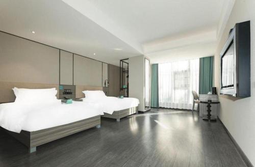 a bedroom with two beds and a large window at Xana Lite Xichang Hangtian Avenue Branch in Xichang