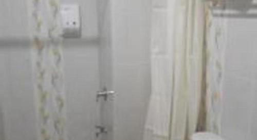a bathroom with a shower curtain and a toilet at GARDEN HOTEL MAJALENGKA in Majalengka
