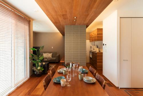 YugeにあるMOVA VILLA Koshi Sekisui 1の木製のテーブルと椅子のあるダイニングルーム