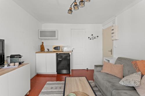 un salon avec un canapé et une cuisine dans l'établissement Cosy Studio, Cannes centre, à Cannes