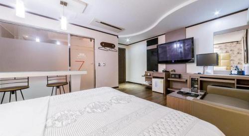 a hotel room with a bed and a bar and a tv at Seven Motel Ansan in Ansan