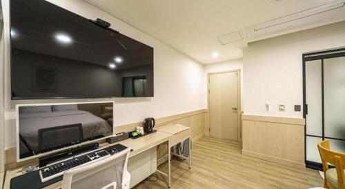 a room with a bed and a flat screen tv at Seven Motel Ansan in Ansan