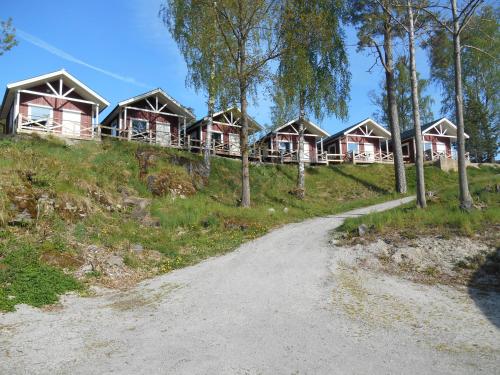 una casa en una colina con un camino de tierra en Visitor Stugby en Håverud