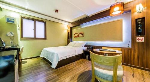 a bedroom with a bed and a desk and a table at Seven Motel Ansan in Ansan