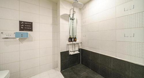 a white tiled bathroom with a sink and a toilet at Seven Motel Ansan in Ansan