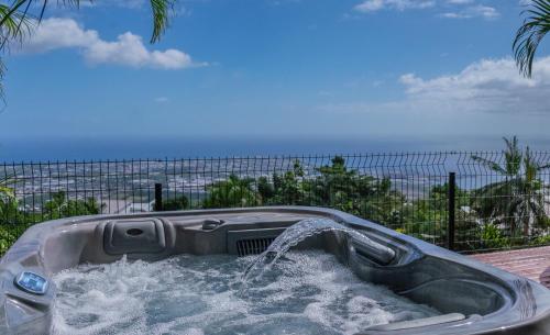 ラ・ポッスシオンにあるSea View & Spaの海を背景に水を満たした浴槽