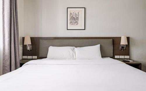 a hotel room with two beds and two lamps at Cozy 1 Studio Room - The Residences BGC Taguig in Manila