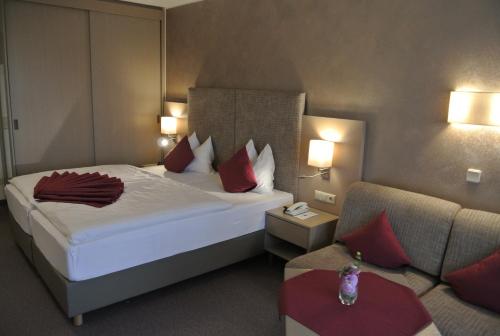 a hotel room with a bed and a couch at Dei Hotel Schönblick in Velden am Wörthersee