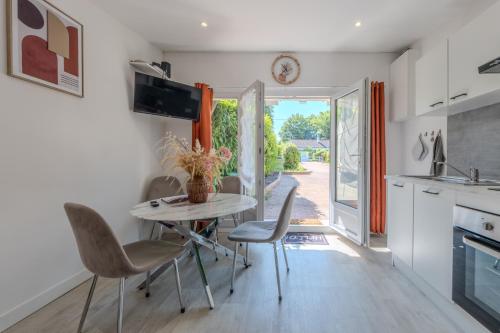 une cuisine et une salle à manger avec une table et des chaises dans l'établissement Le Refuge de Victoire et Gabriel, à Ingrannes