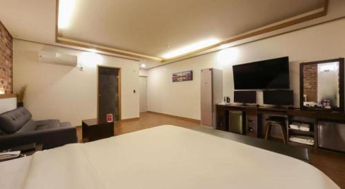 a hotel room with a bed and a television at H Hotel in Ulsan