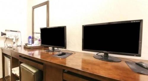 a desk with two monitors on top of it at H Hotel in Ulsan