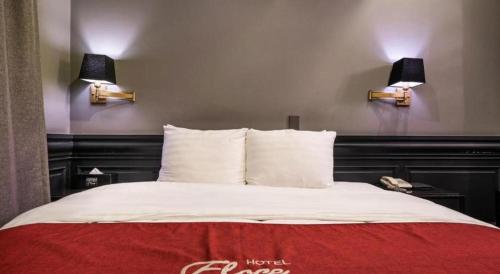 a bedroom with a bed with two lights on the wall at Hotel Floce in Bucheon