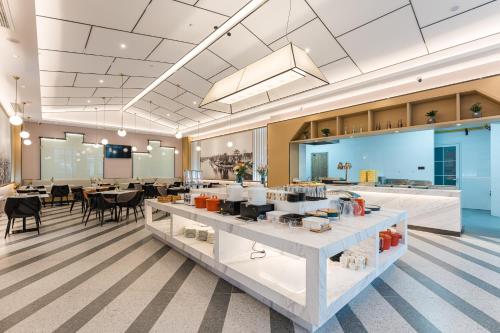 a lobby with a cafeteria with tables and chairs at Atour Hotel Suzhou Wangting in Suzhou