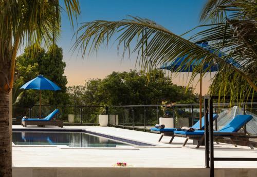 a swimming pool with two lounge chairs and a slide at WiNy Kubu Reod in Sukasada