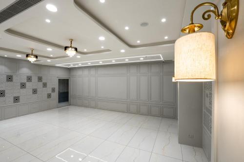 a large room with a white tile floor and a ceiling at Prarambh By Siara in Nadiad